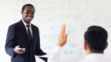 Sınıfta Afrikalı öğretmen fen dersi veriyor.