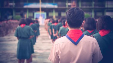 Üniformalı gözcü okulda dikiliyor.