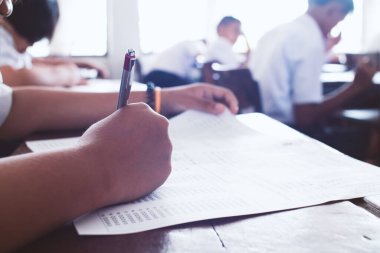 Öğrenciler sınıfta baskı altında yazıyor ve sınava giriyorlar..
