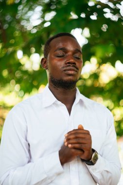 Afrikalı adam yeşil doğada Tanrı 'ya dua ediyor.
