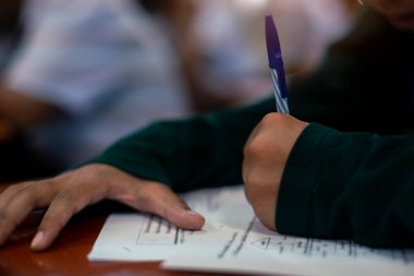 Sınav sorularını okuma ve yazma öğrencilerini kapatın. Sınav kağıtları çalışmalarını stresle yapın..