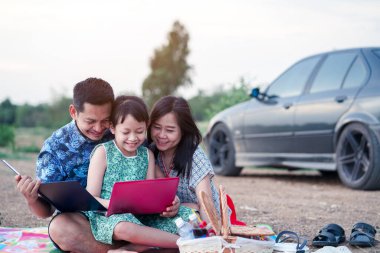 Mutlu aile parkta piknik yapıyor.