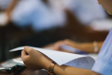 Sınav sorularını yazan ve okuyan öğrenciler, okuldaki sınav kağıtlarını stres ile okuyorlar.