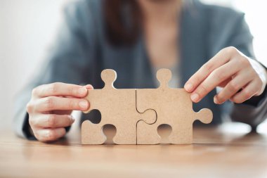 İş çözümleri ortaklığı ve strateji konsepti, İş kadını eli masa başındaki yapbozu bağlıyor.