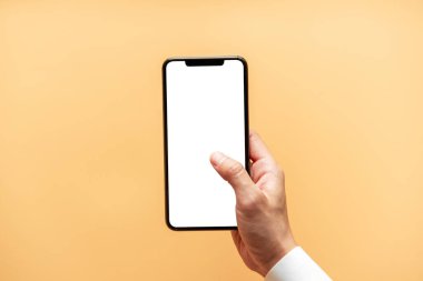 Akıllı telefon maketi. Sarı arka planda siyah telefon beyaz ekranını tutarak elinizi kapatın. Cep telefonu çerçevesiz tasarım kavramı.