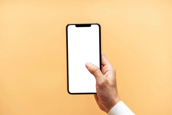 Akıllı telefon maketi. Sarı arka planda siyah telefon beyaz ekranını tutarak elinizi kapatın. Cep telefonu çerçevesiz tasarım kavramı.