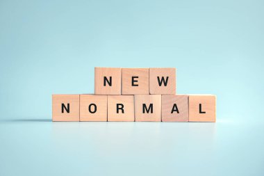 Yeni normal kelimeli ahşap küpler. Coronavirüs salgınından sonra yeni bir hayata ya da iş hayatına adapte olmak. Sosyal mesafeli kişisel hijyenle iş.