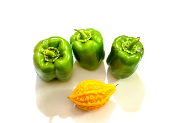 黄苦葫芦介于具有孤立背景的绿色辣椒之间 单生的 — 图库照片