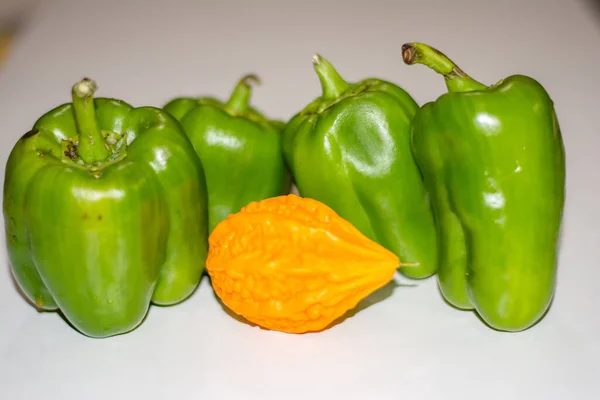 黄苦葫芦介于具有孤立背景的绿色辣椒之间 单生的 — 图库照片