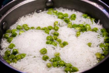 Hint pilavı ya da sebze pilavı taze bezelye kabuğuyla kabarmış pirinç, bezelye. Siyah arkaplanda izole. 