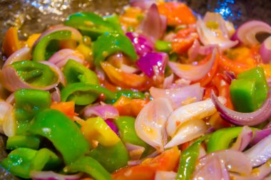 Tavada kızartılmış renkli sebzeler, sağlıklı yiyecekler. Lezzetli ve sağlıklı bir vejetaryen yemeği konsepti. Kapat.