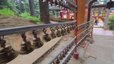 Haat Kalika Tapınağı 'nda asılı duran zillerin 4K videosu. Hint tapınağının pirinç çanları seriler halinde sallanıyor. Ünlü Haat Kalika tapınağı, Gangolihat Pithoragarh bölgesi, Uttrakhand
