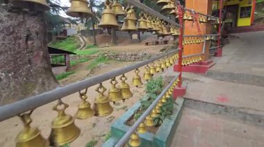 Haat Kalika Tapınağı 'nda asılı duran zillerin 4K videosu. Hint tapınağının pirinç çanları seriler halinde sallanıyor. Ünlü Haat Kalika tapınağı, Gangolihat Pithoragarh bölgesi, Uttrakhand