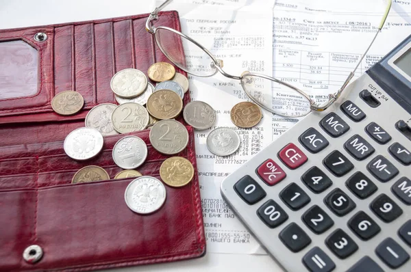 Boş bir cüzdan, hesap makinesi, bardaklar ve paralar çeklerin üzerine konur.