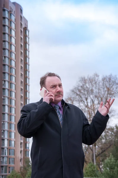 Telefonda el kol hareketi yapan bir adam.