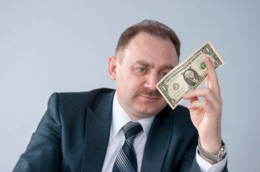 Erkek elinde bir dolara bakar.