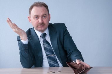 Boş cüzdan gösteren takım elbiseli bir erkek.