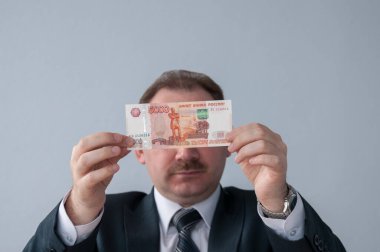 İşadamı beş bin rubleden iki elini tutuyor.