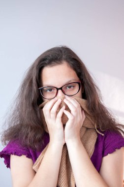 Hastalık, kız ağzını bir eşarpla kapatıyor.