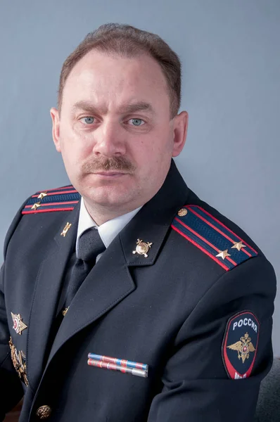 Male with a mustache in a police uniform
