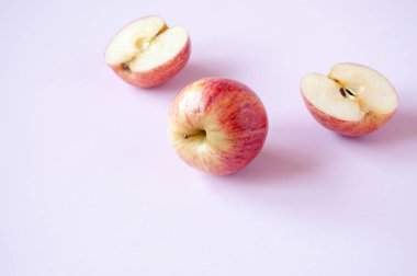 Pembe arkaplanda kırmızı elmayı kes ve tamamla