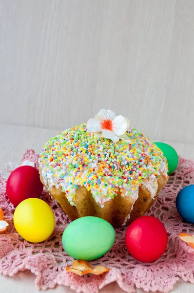 Masadaki Paskalya pastası pembe peçete ve renkli yumurtalar.