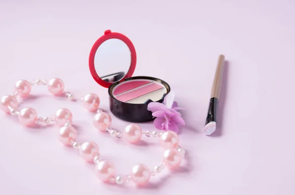 Błyszczyk Ust Lustrem Kwiatem Pędzlem Kosmetycznym Perłowym Naszyjnikiem Różowym Tle — Zdjęcie stockowe