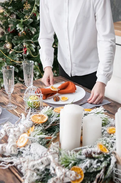A brunette waitress serves a festive table for the new year