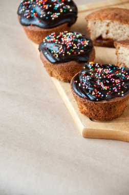 Masanın üzerinde taze kekler çikolata ve dekoratif serpiştirilmiş ahşap bir domuza çapraz serpiştirilmiş.