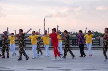 Çin, Heihe, Temmuz 2019: Halk yazın Heihe 'deki Amur nehir setinde toplu egzersiz yapıyor