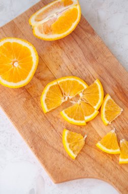 Bir portakal dilimi masanın üzerindeki tahtanın üzerinde duruyor.