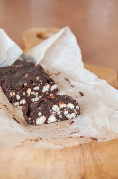 クッキーのクラムとチョコレートデザート ソーセージケーキ 紙の上に作品にカット — ストック写真