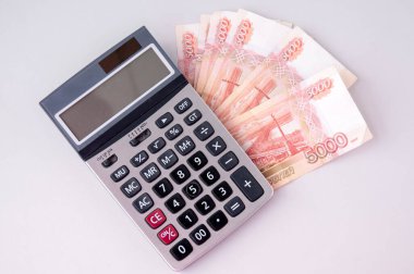 Hesap makinesi beş bin dolarlık banknotlara dayanıyor, büyük para kavramı.