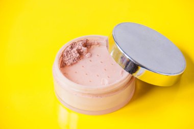 Sarı arka planda gevşek tozlu kavanozu aç