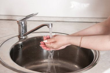 Bir kadın ellerini güzel bir manikürle yıkar.