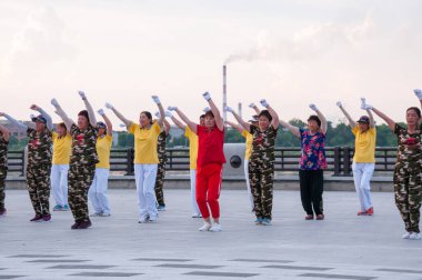 Çin, Heihe, Temmuz 2019: Halk yazın Heihe 'deki Amur nehir setinde toplu egzersiz yapıyor