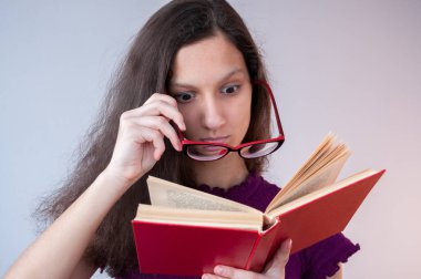 Gözlüklü kız kitabı okuyunca şaşırdı.