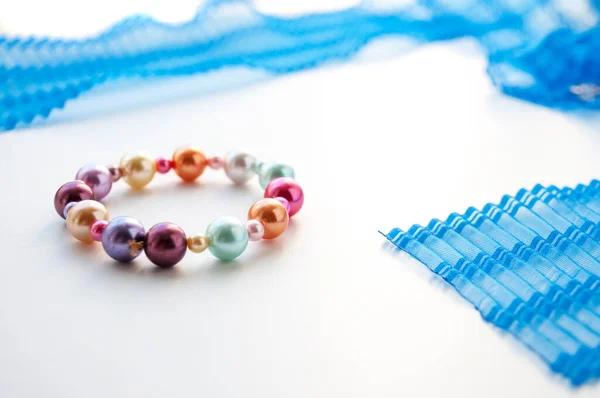 Bracelet Colored Pearls Lies Next Blue Ribbon — Stock Photo, Image