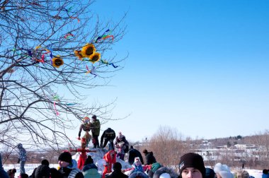 Rusya, Khabarovsk, 25 Şubat: Shrovetide, elinde korkuluk olan bir tepedeki insanlar