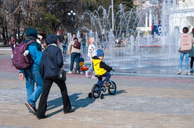 Rusya, Khabarovsk, 1 Mayıs 2018: İnsanlar Khabarovsk şehrinin eğlence parkında yaya ışık dinamik çeşmesinde yürüyorlar.