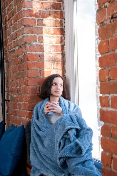 秋の窓辺の窓辺には毛布に包まれたお茶の女の子 快適さと暖かさの概念 — ストック写真