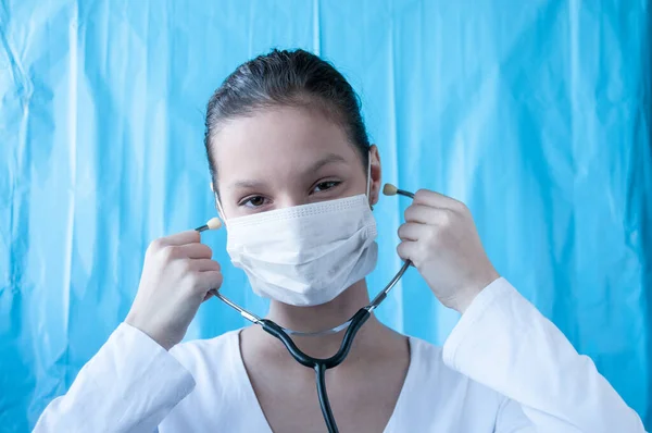 Girl brunette doctor in mask with stethoscope
