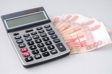 Hesap makinesi beş bin dolarlık banknotlara dayanıyor, büyük para kavramı.