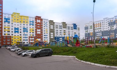 Çocuk parkı ve araba parkı olan modern bir mahalle.