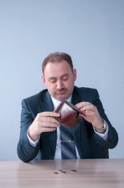 Takım elbiseli bir erkek çantadan son parayı döktü.