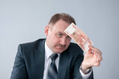 Takım elbiseli adam beş bin rubleye bakıyor.