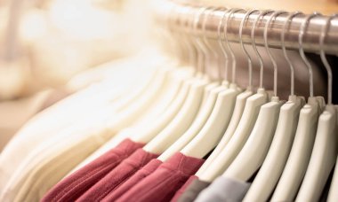 Modern moda kadın kıyafetleri giyim mağazasındaki dayanıksız çelik askılara asılıyor. İnternetten günlük kıyafet alışverişi. 