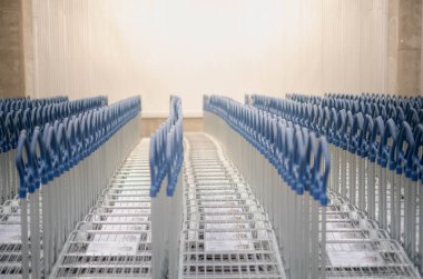 Birçok büyük metal alışveriş arabaları bir otoparktaki iç mobilyalar için müşteriler için mağazadan alışveriş yapıyor..