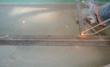 İşçi, fabrikada Meşale ve Koruyucu Miğfer ile kaynak yapıyor..