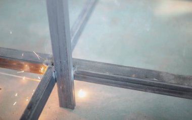 İşçi, fabrikada Meşale ve Koruyucu Miğfer ile kaynak yapıyor..